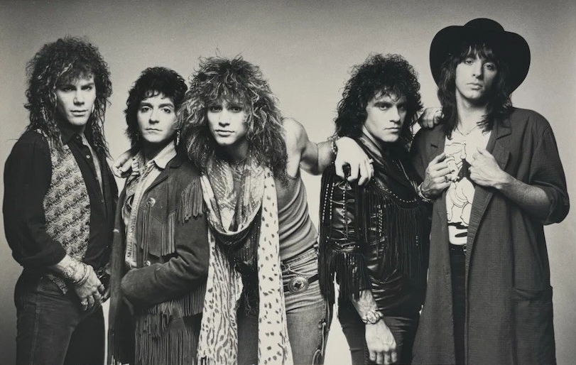 Bon Jovi in 1986: David Bryan, Alec John Such, Jon Bon Jovi, Tico Torres, and Richie Sambora in a black and white publicity photo from the Slippery When Wet era